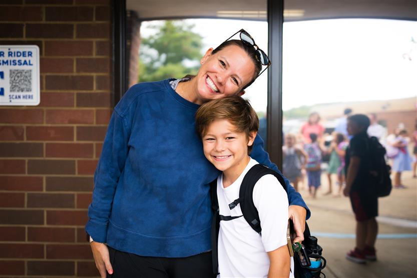 A family smiles on the first day of school at Edmondson Elementary